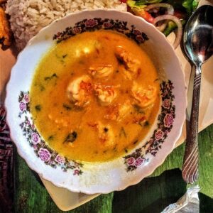 Encocado de jaiba servido en plato hondo con arroz blanco y patacones